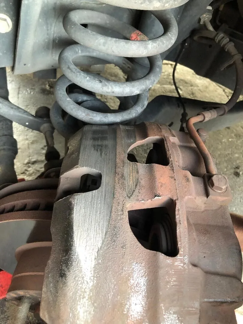 Worn suspension coil spring and brake parts found during auto repair in West Columbia, SC