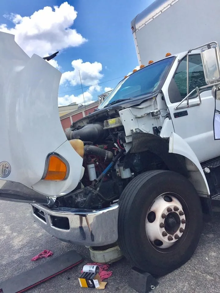 White diesel box truck with the hood open for repair in West Columbia, SC