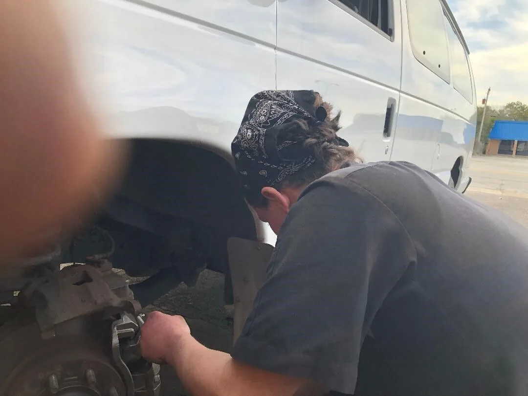 Mechanic performing brake repair on a van in West Columbia, SC
