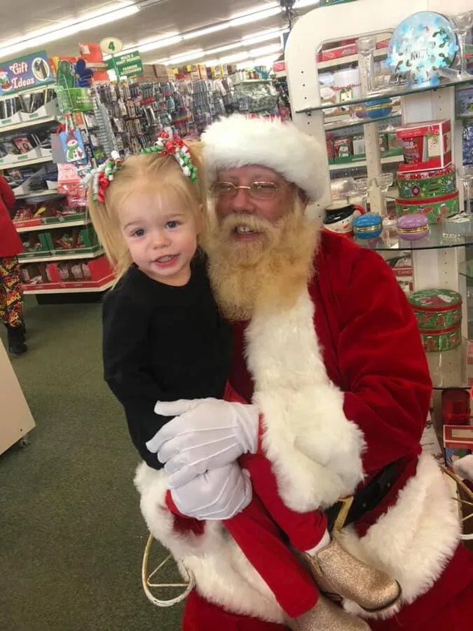 Toddler sitting with Santa at the Scott's Auto community event in West Columbia, SC