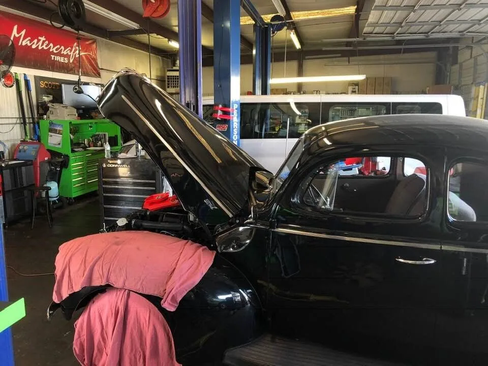 Classic black car with the hood open for engine service in West Columbia, SC